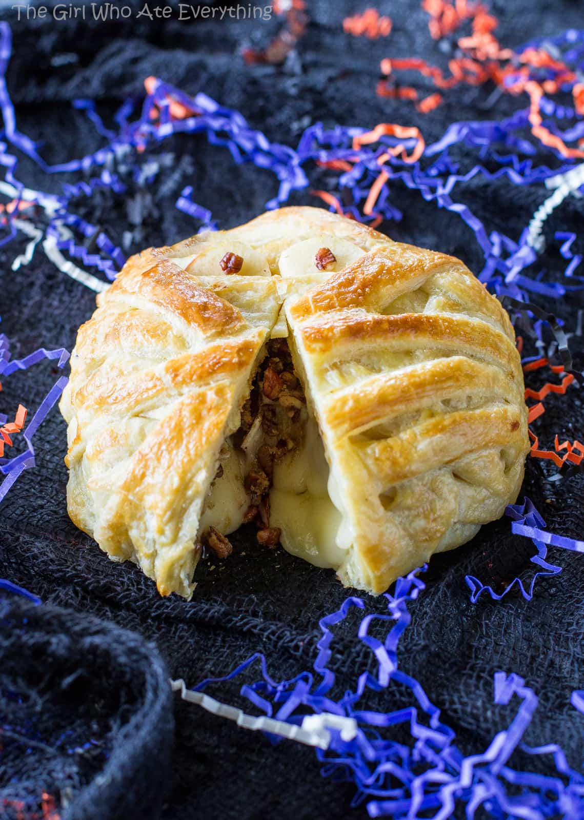 Mummy Wrapped Brie - topped with brown sugar and cinnamon pecans, baked inside puff pastry until nice and gooey. The best appetizer for Halloween! the-girl-who-ate-everything.com