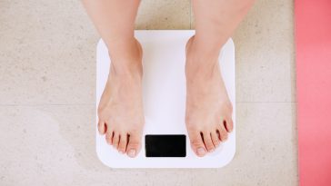 person standing on white digital bathroom scale stockpack unsplash scaled - 7 Tips For Sustainable Weight Loss
