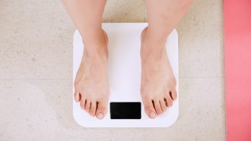 person standing on white digital bathroom scale stockpack unsplash scaled - 7 Tips For Sustainable Weight Loss