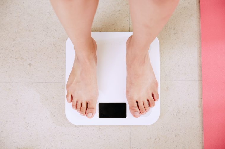 person standing on white digital bathroom scale stockpack unsplash scaled - 7 Tips For Sustainable Weight Loss
