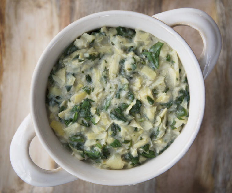 Flat lay of vegan spinach artichoke dip in bowl