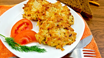 Fritters chicken with vegetables and bread on a board