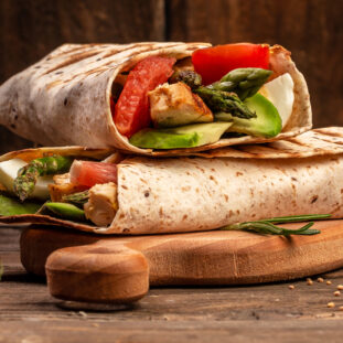 Tortilla wrap with asparagus, cherry tomatoes, avocado, chicken fillet and fresh salad. healthy food. Top view. Long banner format. space for text.