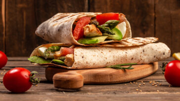 Tortilla wrap with asparagus, cherry tomatoes, avocado, chicken fillet and fresh salad. healthy food. Top view. Long banner format. space for text.