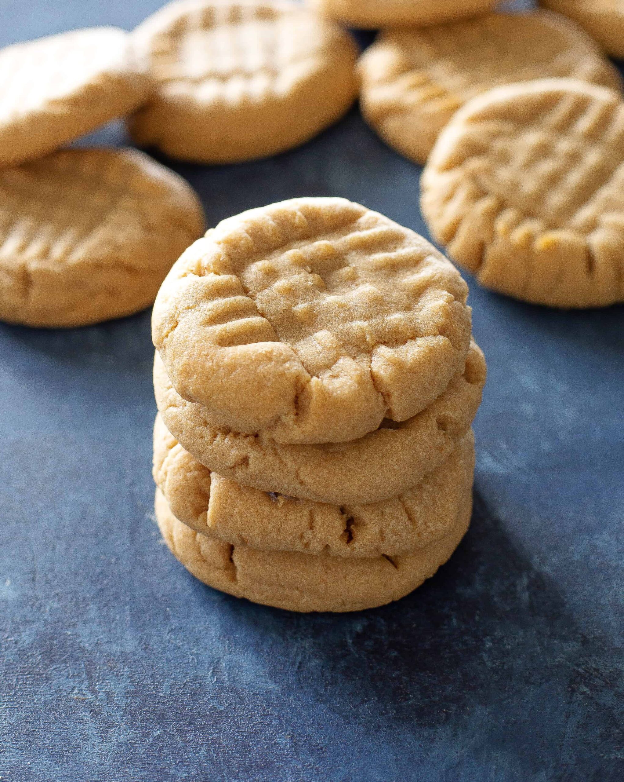 peanut butter cookies in a stack on a blue background